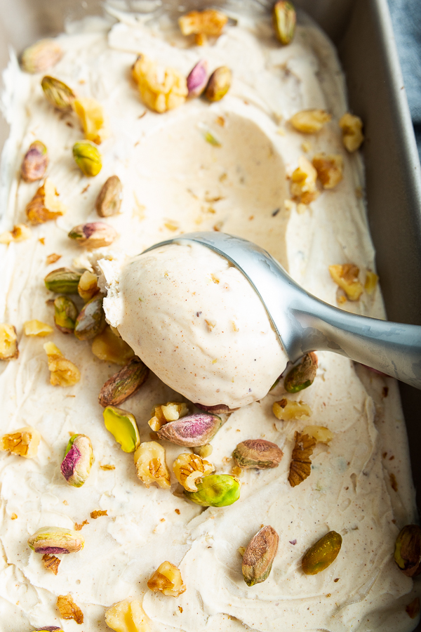 Ice cream scoop, scooping walnut and pistachio topped baklava ice cream.