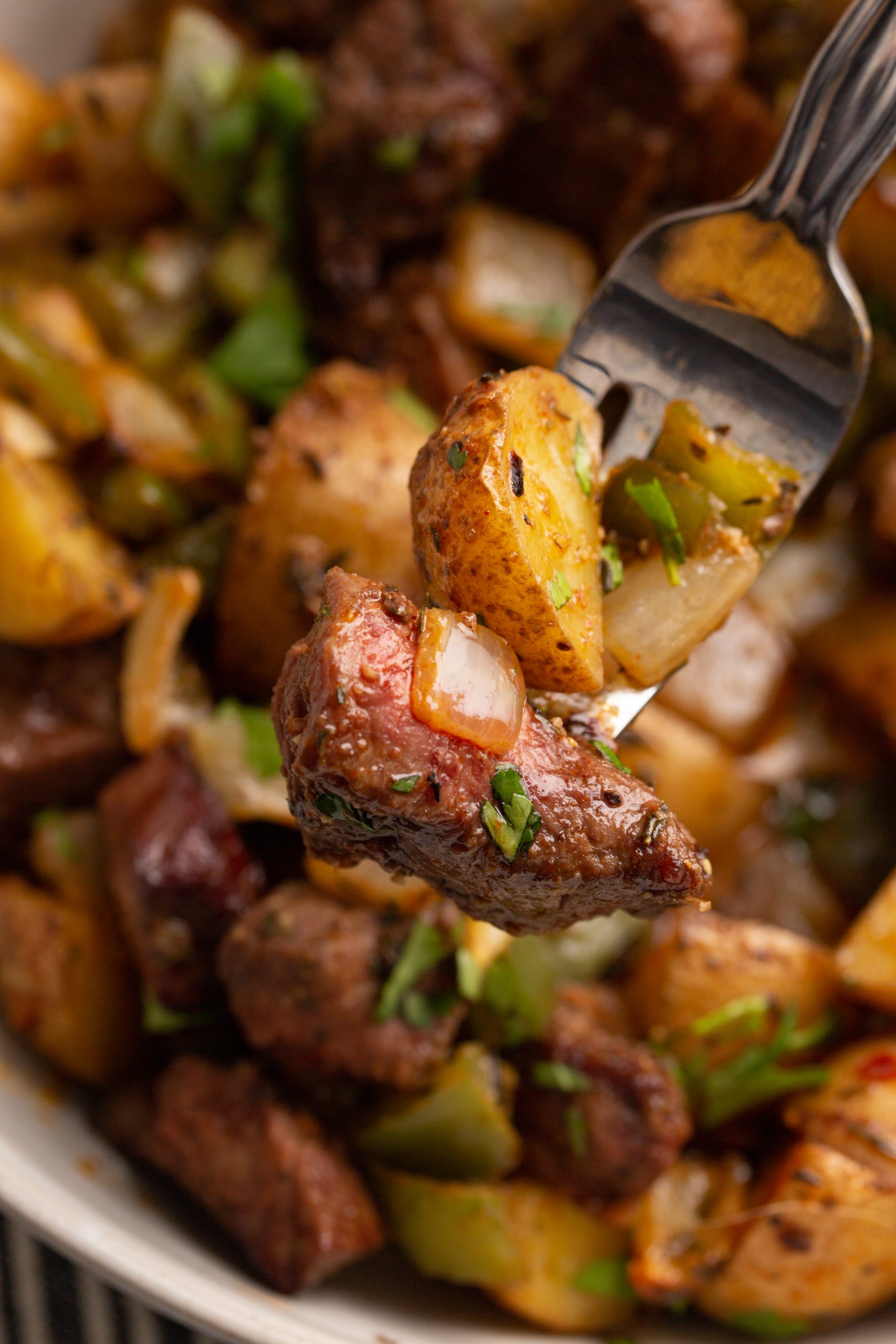 close up of steak tips and potatoes on a fork