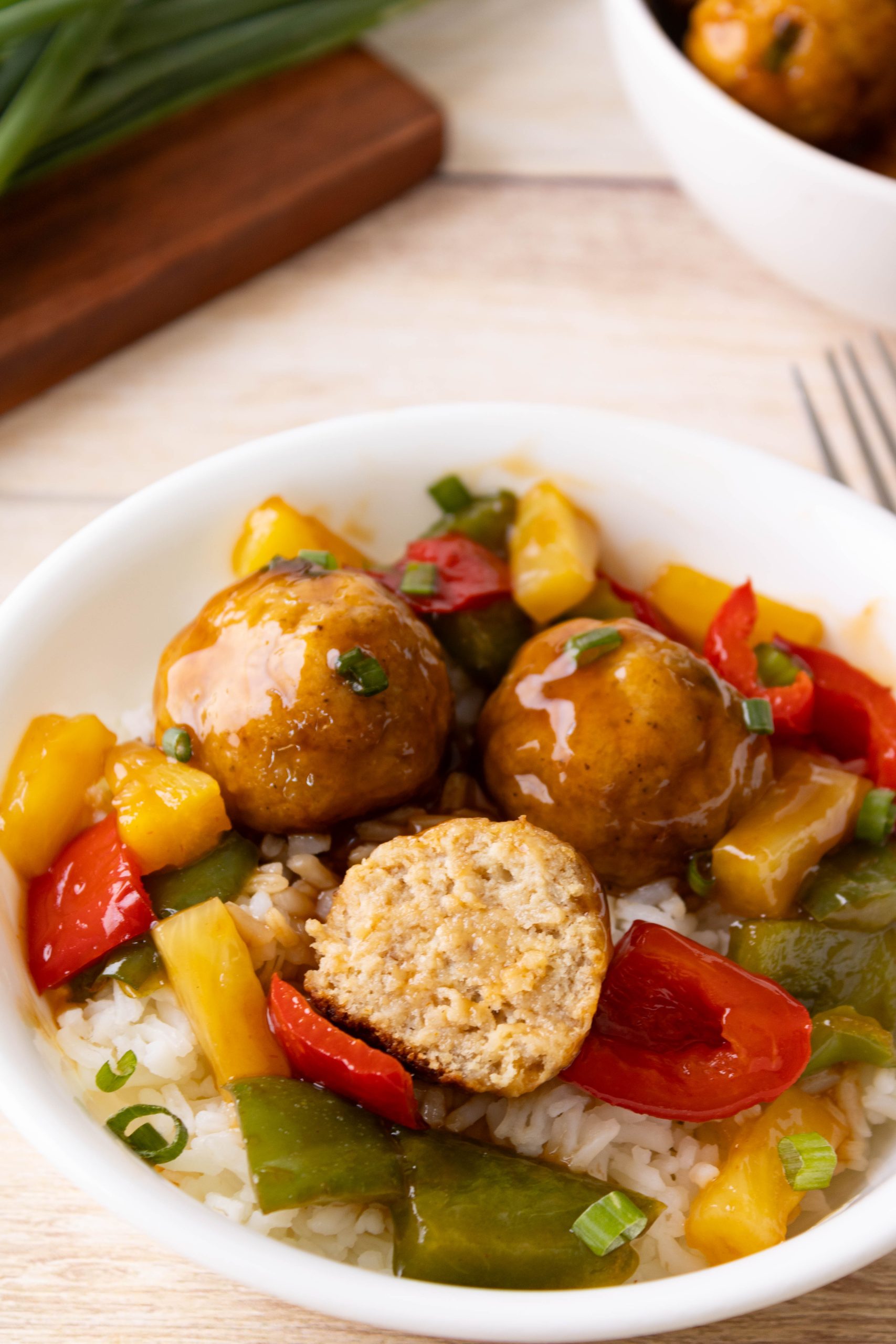 sweet and sour baked chicken meatballs in rice and pepper bowl.